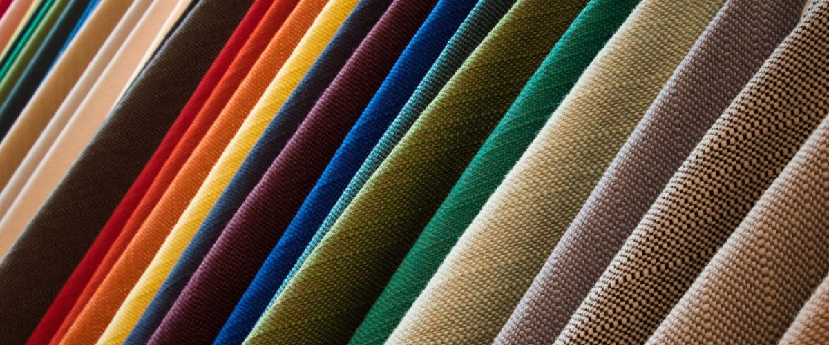A line of hanging textured fabrics of different colors and shades